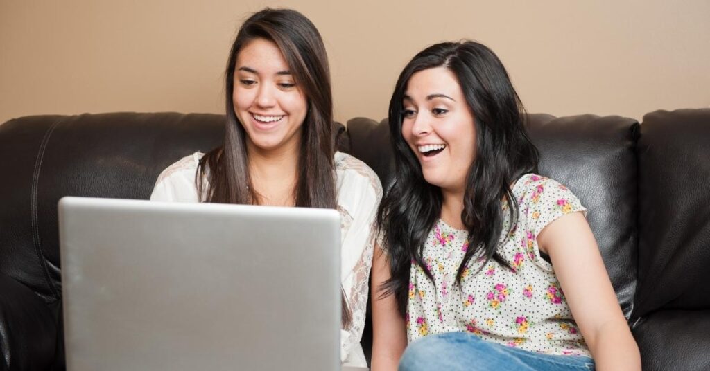 women smiling at laptop