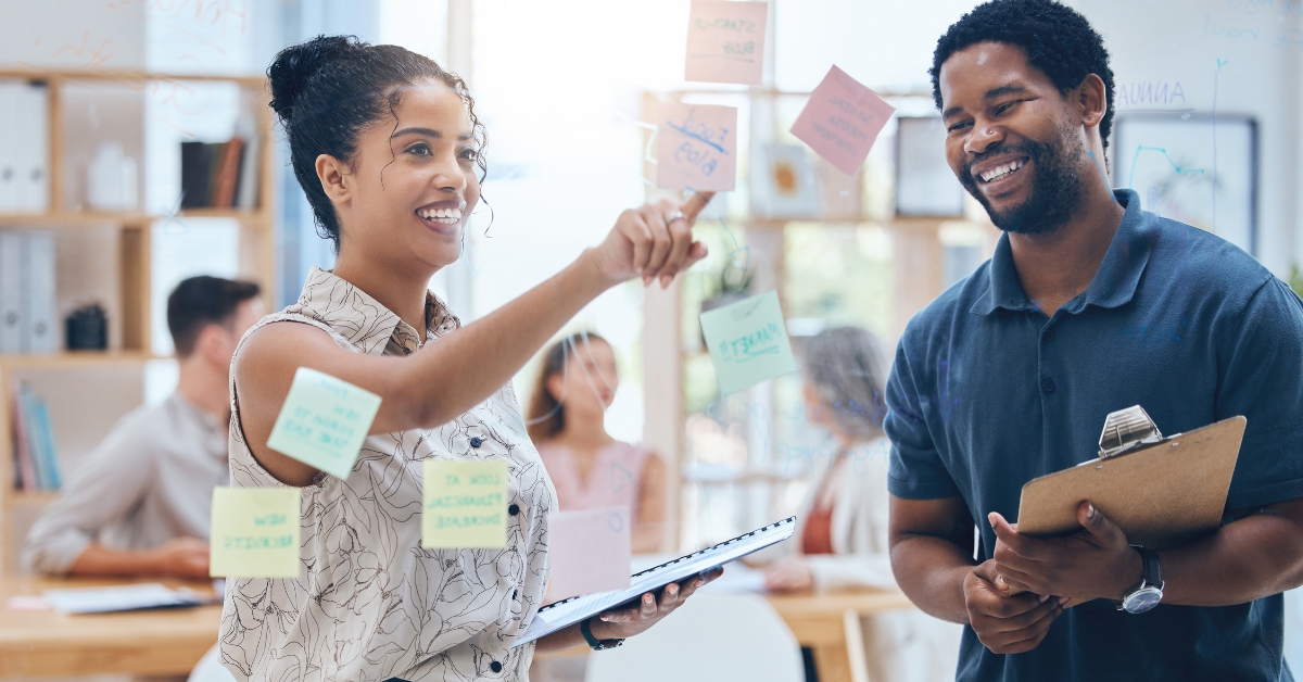 women pointing at sticky notes