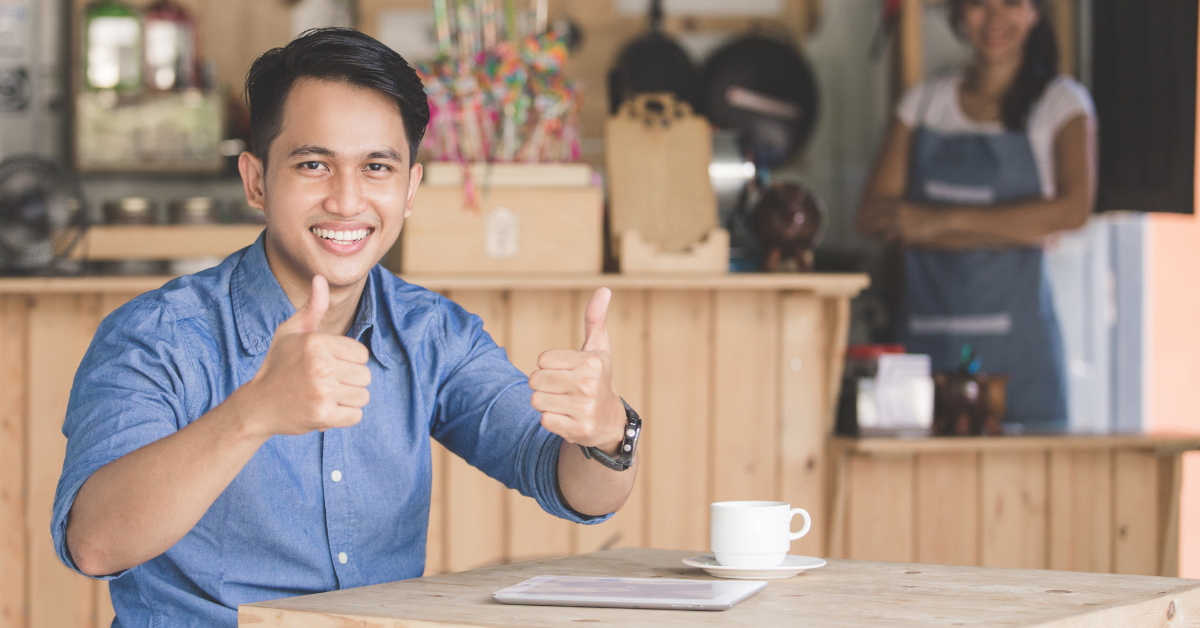 a man sitting and thumbs up