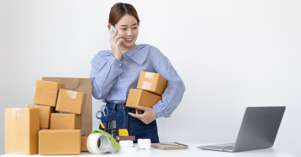 woman holding two parcel while on a call