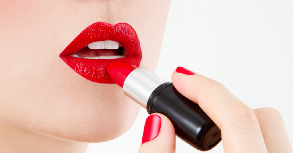 a woman putting on lipstick